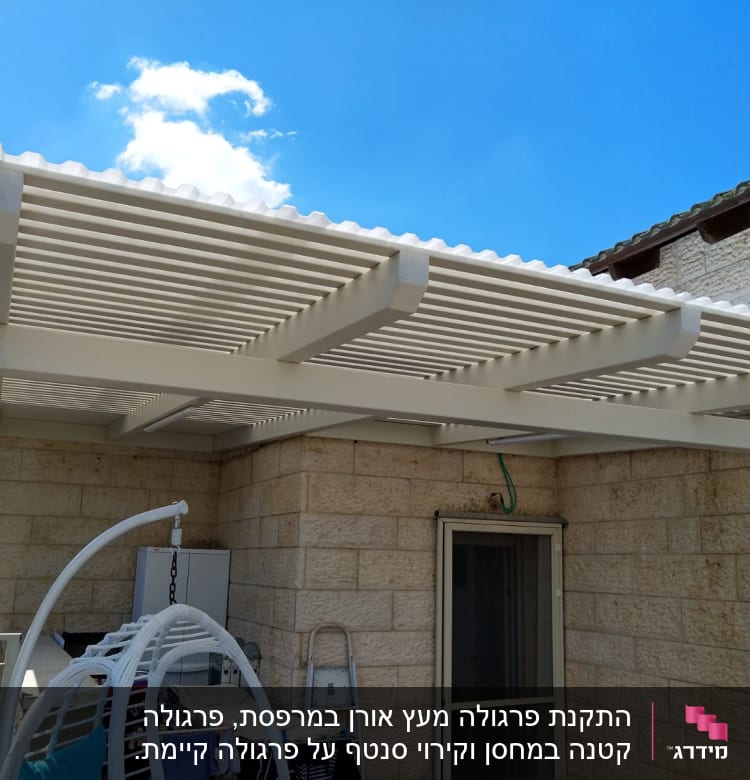 פרגולה לבנה מעץ בחצר עם כביסה תלויה